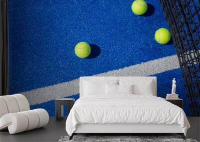 four balls near the net in a blue paddle tennis court view from above Wall mural