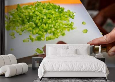 selective focus, hand of a person dicing a green bell pepper for a cooking recipe Wall mural