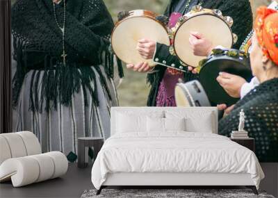 women dressed in traditional Galician costume playing tambourines at a popular festival, folk music event Wall mural