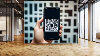 A hand holds a smartphone with a clear QR code on the screen against a geometric patterned backdrop, symbolizing digital access and connectivity. Wall mural