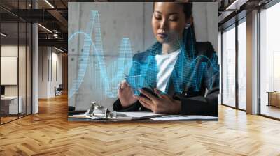 Businesswoman typing phone, work in modern office on new project. Financial graph hologram. Double exposure. Concept of success. Wall mural