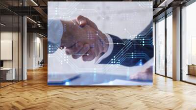 Handshake of two businessmen who enters into the contract to develop a new software to improve business service at a company. Technological icons over the table with the document. Wall mural