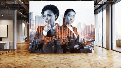 Two young attractive businesswoman in suits pondering about new venture capital and hi-tech start up and try to forecast risks and estimate prospective earning growth. Hologram chart on Kuala Lumpur. Wall mural