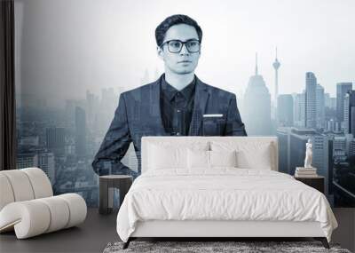 Young handsome businessman in suit and glasses dreaming about new career opportunities after MBA graduation. Kuala Lumpur on background. Double exposure. Wall mural