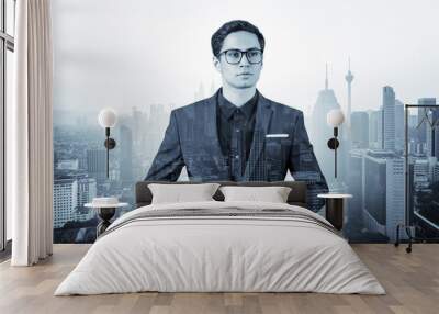 Young handsome businessman in suit and glasses dreaming about new career opportunities after MBA graduation. Kuala Lumpur on background. Double exposure. Wall mural