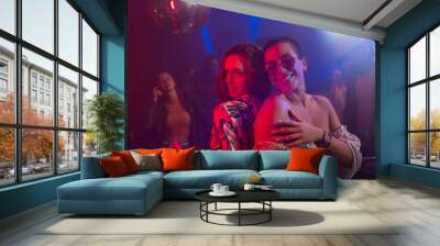 Image of two female friends dancing together in front of a crowd in disco Wall mural