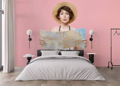 Amazed young tourist woman in summer white dress hat with photo camera isolated on pink background studio. Female traveling abroad to travel weekend getaway. Air flight journey concept. Hold city map. Wall mural