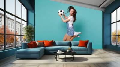 Blinking girl football fan cheer up support favorite team holding soccer ball jumping isolated on blue turquoise background. People emotions sport family leisure lifestyle concept. Mock up copy space. Wall mural