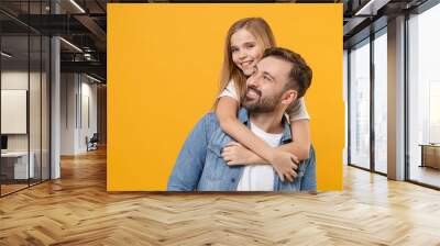 Cheerful bearded man in casual clothes have fun with cute child baby girl. Father little kid daughter isolated on yellow background in studio. Love family day parenthood childhood concept. Hugging. Wall mural