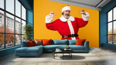 Cheerful elderly gray-haired mustache bearded Santa man in Christmas hat isolated on yellow background. Happy New Year 2020 celebration holiday concept. Mock up copy space. Pointing thumbs on himself. Wall mural