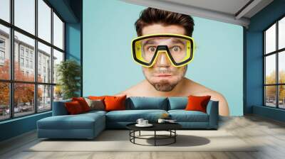 Close up young caucasian man wear shorts swimsuit scuba diving mask relax near hotel pool hold breath look camera isolated on plain light blue cyan background Summer vacation sea rest sun tan concept Wall mural