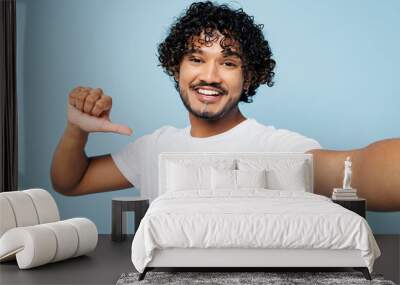 Close up young Indian man he wear white t-shirt casual clothes doing selfie shot pov on mobile cell phone point finger on himself isolated on plain pastel light blue cyan background Lifestyle concept Wall mural