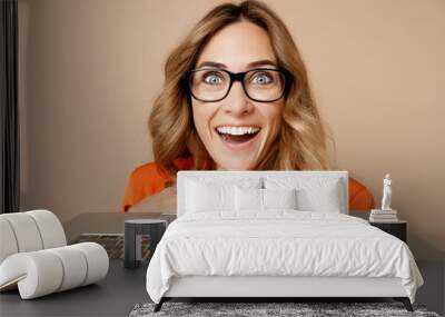 Close up young surprised employee business woman corporate lawyer 30s wear classic formal orange suit glasses work in office typing on pc computer keyboard isolated on plain beige background studio. Wall mural