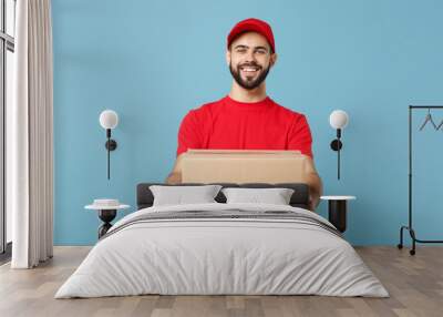 delivery man in red uniform isolated on blue background, studio portrait. male employee in cap t-shi Wall mural