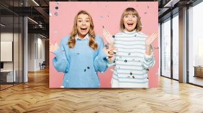 Elder parent mom 50s year old with young adult daughter two women together wear blue casual clothes spread hands in confetti rainfall isolated on plain pastel light pink background Family day concept Wall mural