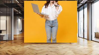 Excited brunette business woman in white shirt glasses isolated on yellow background. Achievement career wealth business concept. Mock up copy space. Working on laptop pc computer, put hand on cheek. Wall mural