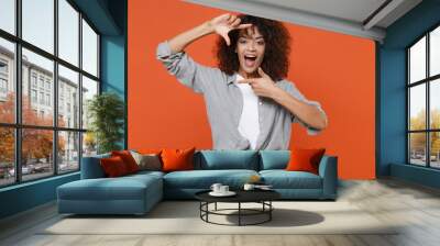 Excited young african american woman girl in gray casual clothes isolated on orange background studio portrait. People emotions lifestyle concept. Mock up copy space. Making hands photo frame gesture. Wall mural