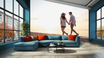 Full body back view young lovely couple two friends family man woman in casual clothes hold hands walking stroll together at sunrise over sea beach ocean outdoor exotic seaside in summer day evening. Wall mural