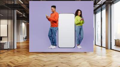 Full body fun young couple two friends family man woman wear casual clothes together big huge blank screen mobile cell phone with area use smartphone isolated on pastel plain light purple background. Wall mural