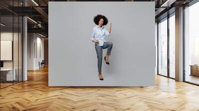 Full body overjoyed excited fun happy young employee business corporate lawyer woman of African American ethnicity in classic formal shirt work in office do winner gesture isolated on grey background. Wall mural