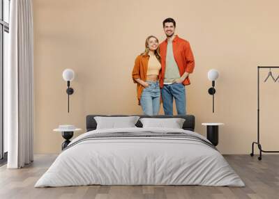 Full body smiling happy cheerful fun cool young couple two friends family man woman wear casual clothes together looking camera hugging isolated on pastel plain beige color background studio portrait. Wall mural