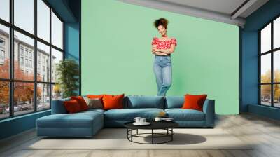 Full body smiling happy young woman she wearing casual clothes red blouse hold hands crossed folded look camera isolated on plain pastel light green color background studio portrait Lifestyle concept Wall mural