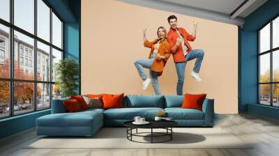 Full body young couple two friends family man woman wear casual clothes together doing winner gesture celebrate clenching fists say yes isolated on pastel plain beige color background studio portrait. Wall mural