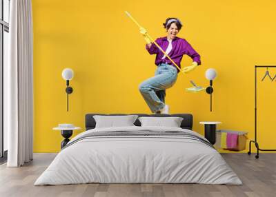 Full body young woman wear purple shirt casual clothes do housework tidy up pov play guitar hold mop bucket water wash floor isolated on plain yellow background studio portrait. Housekeeping concept. Wall mural