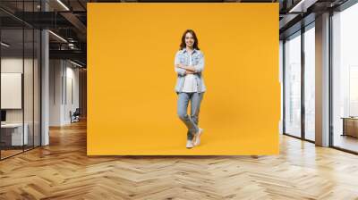 Full length of young caucasian smiling happy confident european cute woman 20s wearing stylish casual denim shirt white t-shirt hold hands crossed folded isolated on yellow background studio portrait Wall mural