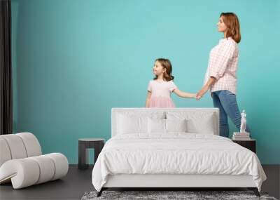 Full length woman in pink clothes have fun with child baby girl 5-6 years old. Mommy little kid daughter walk go step isolated on pastel blue azure background studio. Mother's Day love family concept. Wall mural