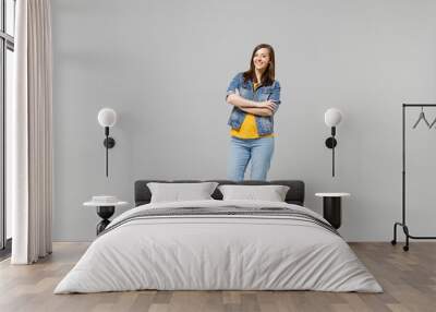 Full length young confident caucasian woman 20s wearing casual denim jacket yellow t-shirt looking camera hold hans crossed folded isolated on grey background studio portrait People lifestyle concept. Wall mural