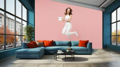 Full length young fun woman in white clothes hold in hand female periods calendar for checking menstruation days jump high isolated on pastel pink background. Medical healthcare gynecological concept Wall mural