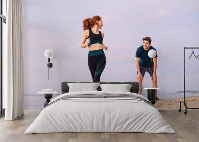 Full size couple young two friends strong sporty sportswoman sportsman woman man wear sport clothes warm up training running on sand sea ocean beach outside jog on seaside in summer day cloudy morning Wall mural