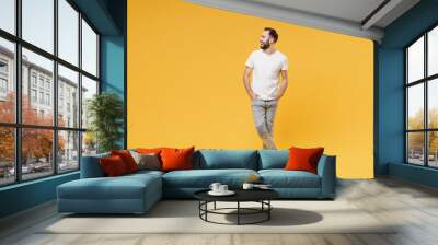 funny young bearded man guy in white casual t-shirt posing isolated on yellow background studio port Wall mural