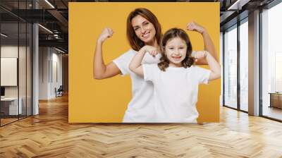 Happy sporty woman in basic white t-shirt have fun with cute child baby girl 5-6 years old. Mom little kid daughter isolated on yellow orange color background studio. Mother's Day love family concept. Wall mural