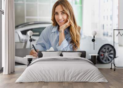 Happy woman customer female buyer client in blue shirt sign agreement document choose auto want to buy new automobile in car showroom vehicle salon dealership store motor show indoor. Sales concept. Wall mural