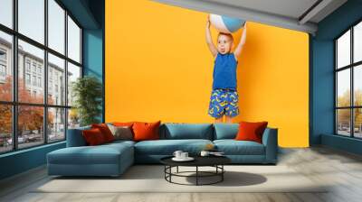 Kid boy 3-4 years old in blue beach summer clothes hold inflatable ball isolated on bright yellow orange wall background children studio portrait. People childhood lifestyle concept Mock up copy space Wall mural