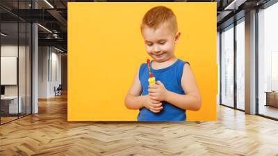 Kid boy 3-4 years old in blue shirt brush his teeth with toothbrush isolated on bright yellow orange wall background, children studio portrait. People, childhood lifestyle concept. Mock up copy space. Wall mural