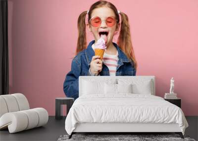 Little child smiling cute kid girl 7-8 years old wears denim shirt glasses have fun eat ice cream close eyes isolated on plain pastel light pink background. Mother's Day love family lifestyle concept. Wall mural