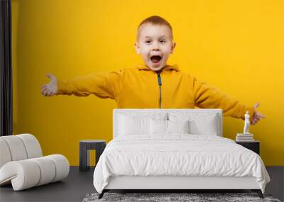 Little cute kid boy 3-4 years old wearing yellow clothes isolated on bright orange wall background, children studio portrait. People sincere emotions, childhood lifestyle concept. Mock up copy space. Wall mural