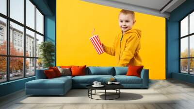 Little fun cheerful kid boy 3-4 years old wearing yellow clothes hold cup of soda isolated on orange wall background, children studio portrait. People, childhood lifestyle concept. Mock up copy space. Wall mural