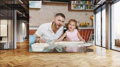 Little kid girl helps man to cook lazy dumplings, forming dough at table. Happy family dad, child daughter cooking food in weekend morning at home. Father's day holiday. Parenthood, childhood concept. Wall mural