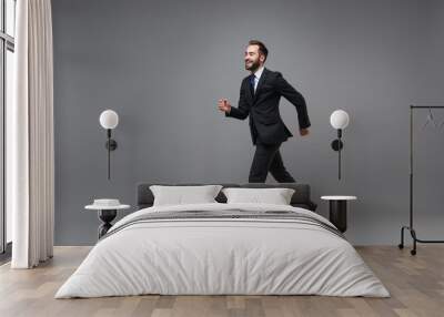 Side view of cheerful young business man in classic suit shirt tie posing isolated on grey background. Achievement career wealth business concept. Mock up copy space. Running, jumping, looking aside. Wall mural