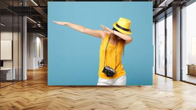 Traveler tourist woman in yellow summer casual clothes, hat with photo camera isolated on blue background. Female passenger traveling abroad to travel on weekends getaway. Air flight journey concept. Wall mural