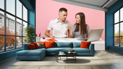 Two young concentrated business woman man colleagues sit work at white desk with contemporary laptop isolated on pastel pink background. Achievement career concept. Copy space advertising, co working. Wall mural