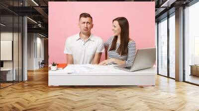 Two young tender business woman man colleagues sit work at white desk with contemporary laptop isolated on pastel pink background. Achievement career concept. Copy space advertising, youth co working. Wall mural