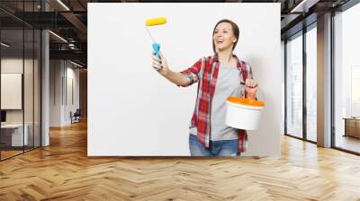 Woman holding empty paint bucket, pointing paint roller for wall painting on copy space isolated on white background. Instruments, accessories, tools for renovation apartment room. Repair home concept Wall mural