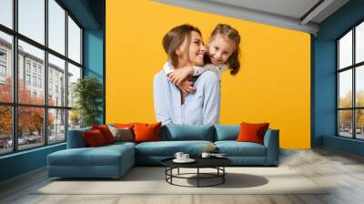 Woman in light clothes have fun with cute child baby girl 4-5 years old. Mommy little kid daughter isolated on yellow background studio portrait. Mother's Day love family parenthood childhood concept. Wall mural