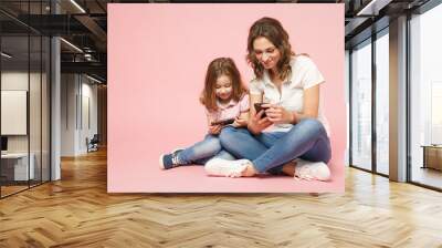 Woman in light clothes have fun with cute child baby girl. Mother, little kid daughter isolated on pastel pink wall background, studio portrait. Mother's Day, love family, parenthood childhood concept Wall mural