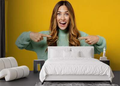 Young amazed surprised exultant fun caucasian woman 30s wearing green knitted sweater point index finger on herself isolated on plain yellow color background studio portrait. People lifestyle concept. Wall mural